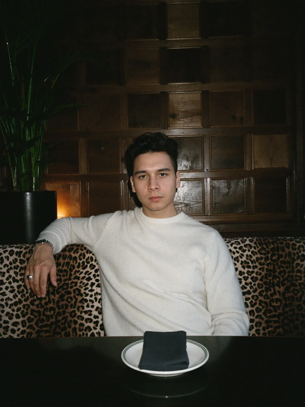 Alex Murillo sitting in a wood-paneled booth